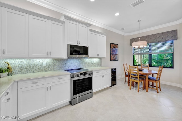 kitchen with appliances with stainless steel finishes, crown molding, white cabinetry, and pendant lighting