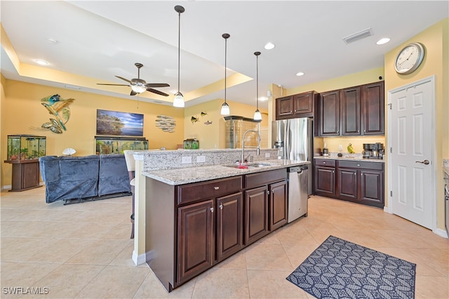 kitchen featuring sink, hanging light fixtures, ceiling fan, a raised ceiling, and stainless steel appliances