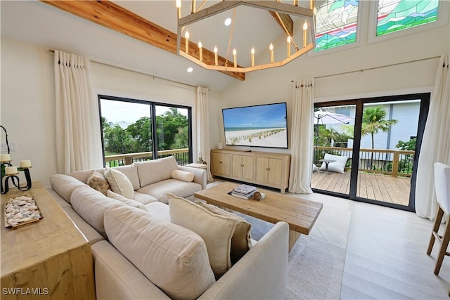 living room with recessed lighting, wood finished floors, a towering ceiling, beamed ceiling, and an inviting chandelier