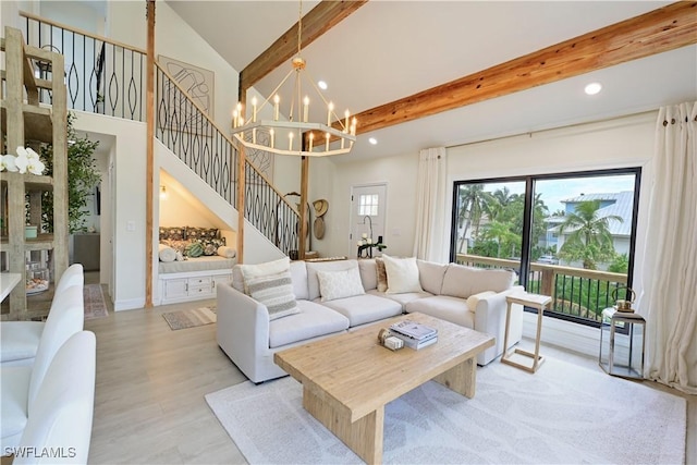 living area featuring light wood-style flooring, beamed ceiling, an inviting chandelier, stairs, and high vaulted ceiling