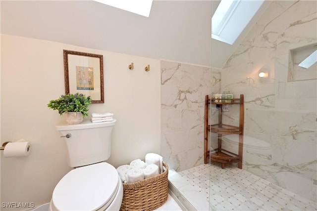 full bath featuring toilet, vaulted ceiling with skylight, and a marble finish shower