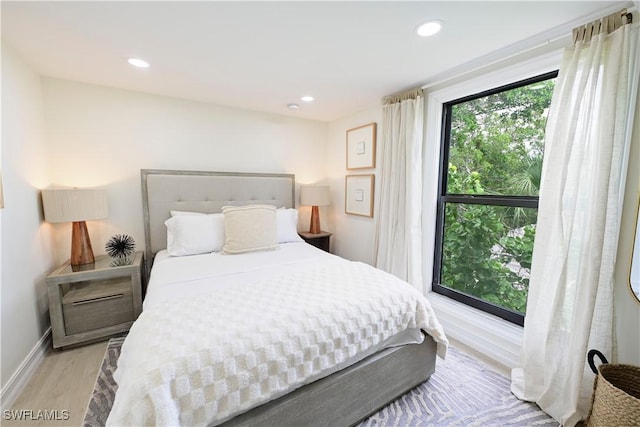 bedroom with baseboards, wood finished floors, and recessed lighting