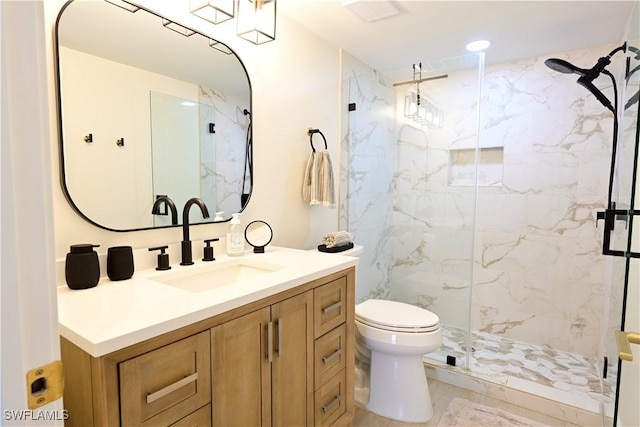 bathroom featuring marble finish floor, vanity, a marble finish shower, and toilet