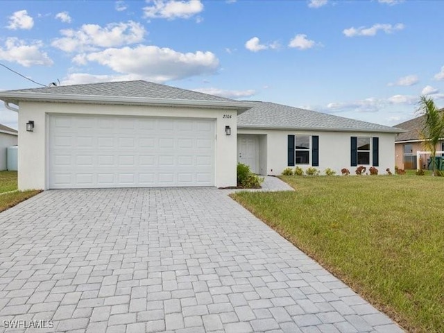 ranch-style home featuring a front yard, decorative driveway, an attached garage, and stucco siding