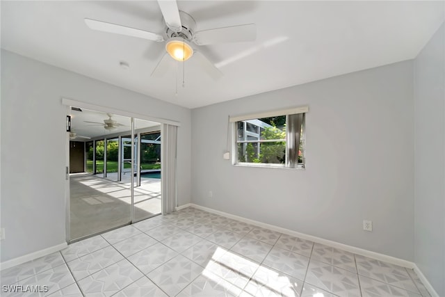 tiled empty room with ceiling fan and french doors