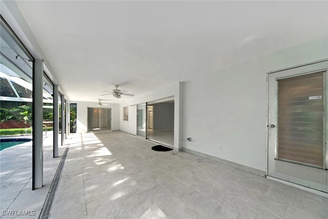 view of patio featuring ceiling fan and a lanai