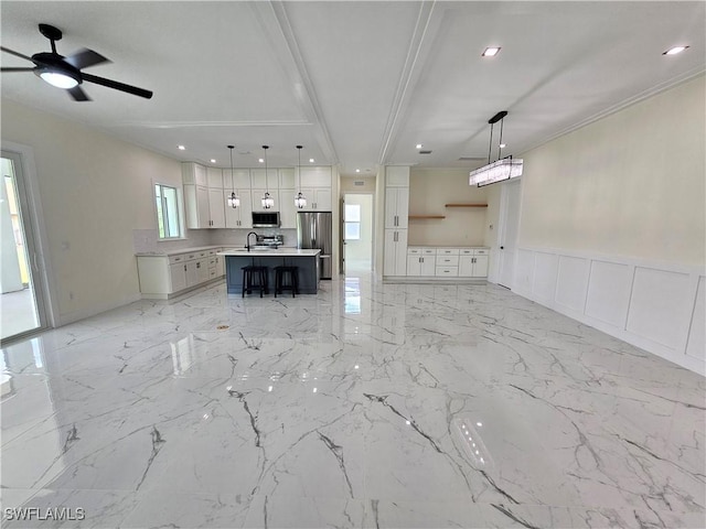 unfurnished living room with ceiling fan, ornamental molding, and sink