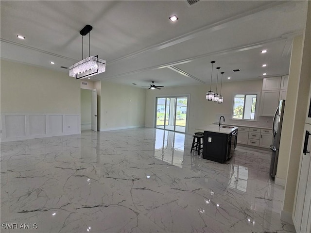 kitchen with pendant lighting, white cabinetry, a kitchen island with sink, and appliances with stainless steel finishes