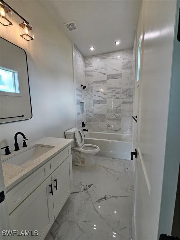 full bathroom featuring vanity, toilet, and tiled shower / bath