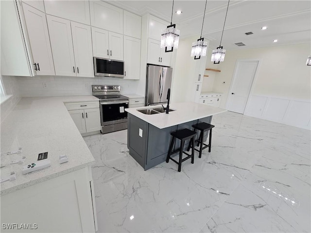 kitchen featuring white cabinetry, sink, hanging light fixtures, an island with sink, and appliances with stainless steel finishes