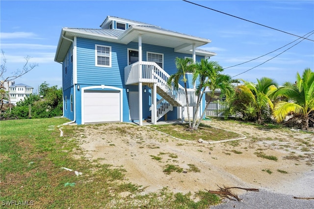 view of front of house featuring covered porch, a garage, and a front yard