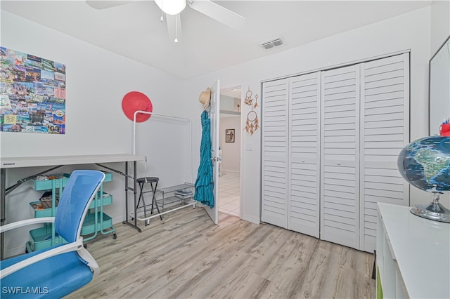 home office with light wood-type flooring and ceiling fan