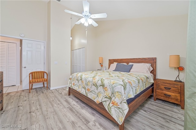 bedroom featuring ceiling fan, light hardwood / wood-style floors, and high vaulted ceiling