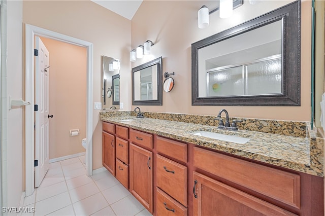 bathroom featuring tile patterned floors, vanity, toilet, and a shower with door