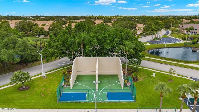 view of basketball court with a yard and a water view