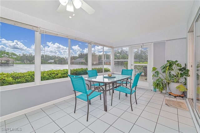 sunroom / solarium with ceiling fan, a healthy amount of sunlight, and a water view