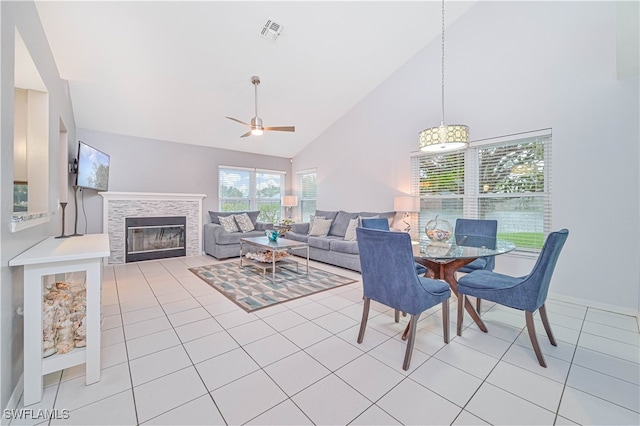 tiled dining room with ceiling fan and high vaulted ceiling