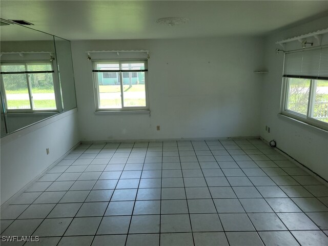 empty room featuring a wealth of natural light and light tile patterned flooring