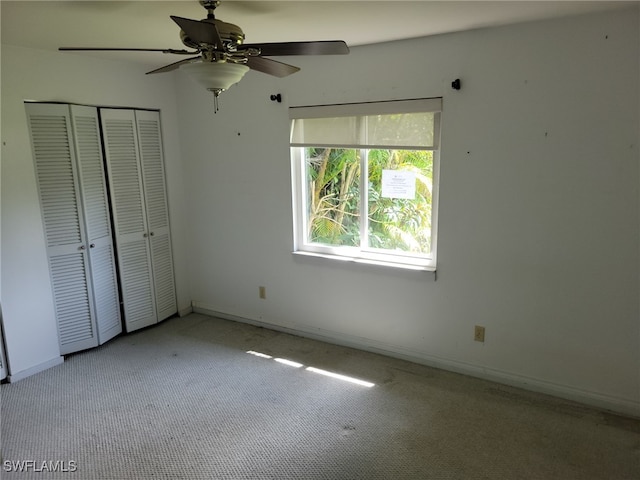 unfurnished bedroom with a closet, ceiling fan, and light colored carpet