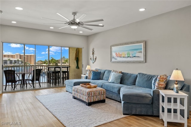 living room featuring light wood-type flooring and ceiling fan