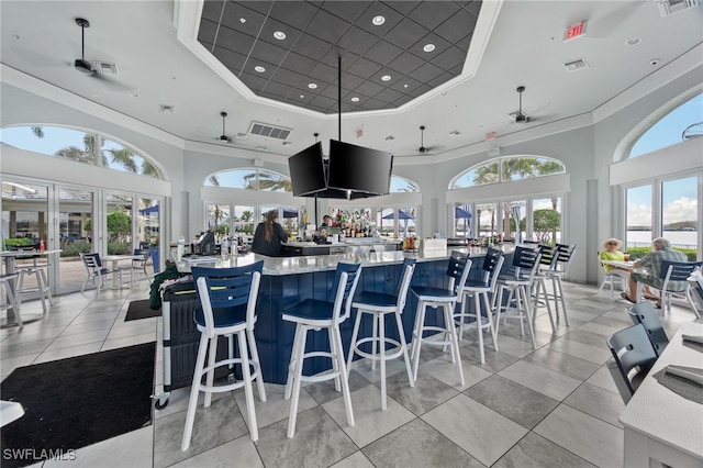 kitchen with a towering ceiling, french doors, a raised ceiling, and ceiling fan