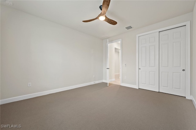 unfurnished bedroom with a closet, carpet flooring, and ceiling fan