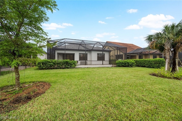 back of property featuring a lanai and a lawn