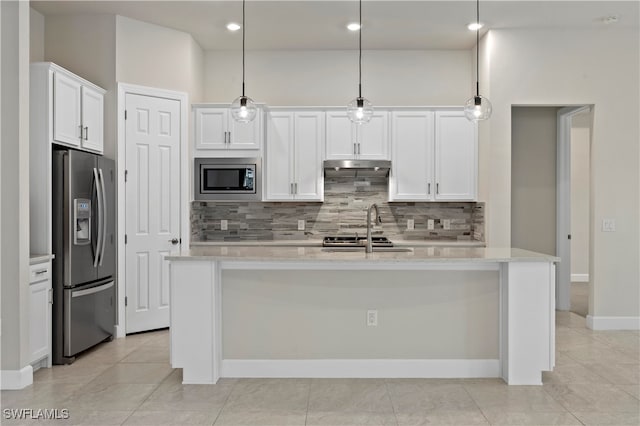 kitchen with a center island with sink, appliances with stainless steel finishes, decorative light fixtures, and white cabinetry