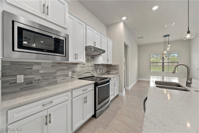 kitchen with hanging light fixtures, stainless steel appliances, sink, light stone countertops, and white cabinetry