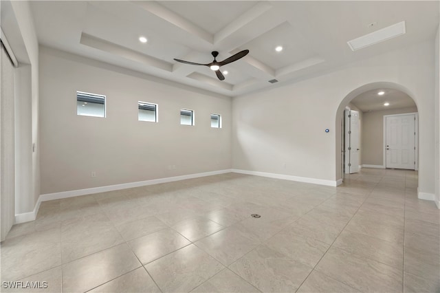 empty room featuring ceiling fan, coffered ceiling, and beamed ceiling