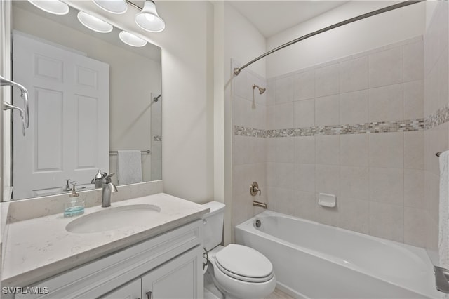 full bathroom featuring vanity, tiled shower / bath combo, and toilet