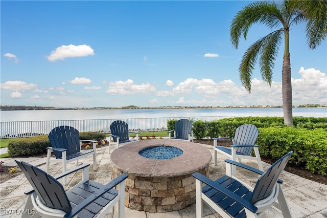 view of patio with an outdoor fire pit and a water view