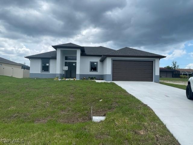 prairie-style home with a front lawn and a garage