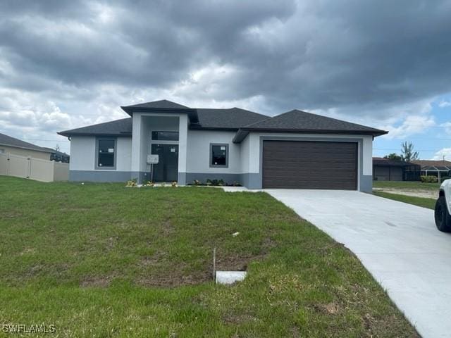 prairie-style home with a garage and a front lawn