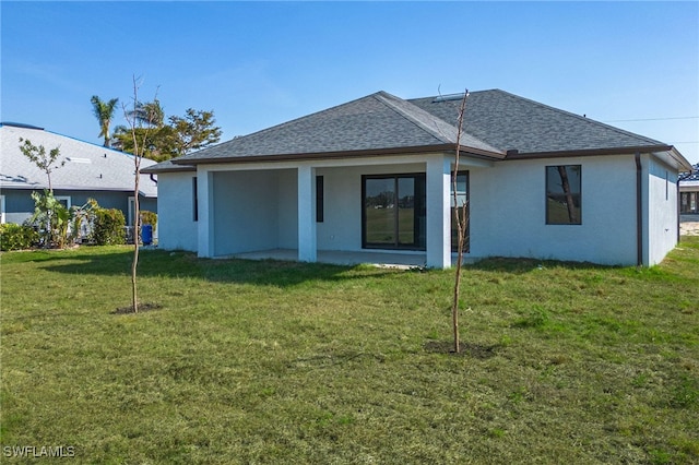 back of house with a patio and a lawn