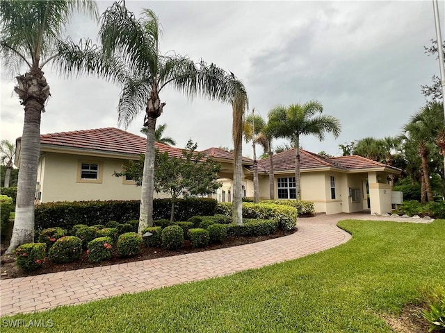 3020 Meandering Way Unit 201, Fort Myers, FL 33905 - rear view of house with stucco siding, a lawn, and a tile roof
