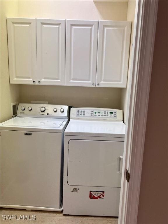 laundry area featuring washing machine and dryer and cabinets