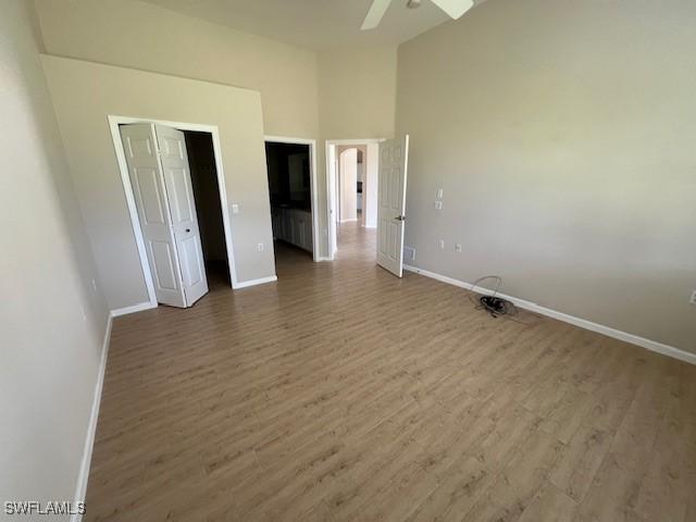 3020 Meandering Way Unit 201, Fort Myers, FL 33905 - unfurnished bedroom featuring wood finished floors, a ceiling fan, and high vaulted ceiling