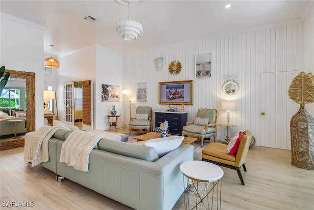 living room with an inviting chandelier and light hardwood / wood-style flooring