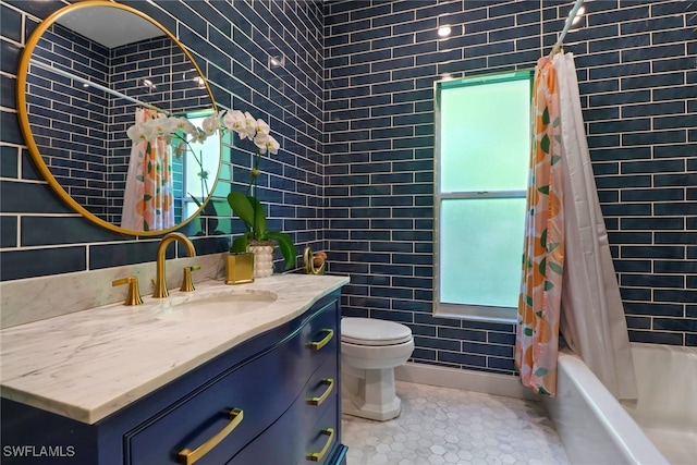 full bathroom with tile patterned floors, toilet, vanity, and tile walls