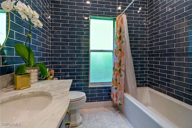 full bathroom featuring vanity, tile patterned flooring, shower / tub combo, tile walls, and toilet