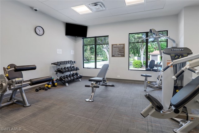 exercise room featuring dark colored carpet and a paneled ceiling