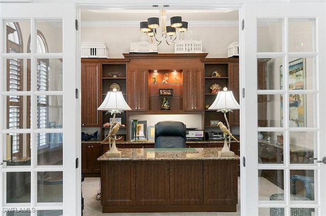 office space featuring carpet flooring, built in desk, ornamental molding, and a chandelier