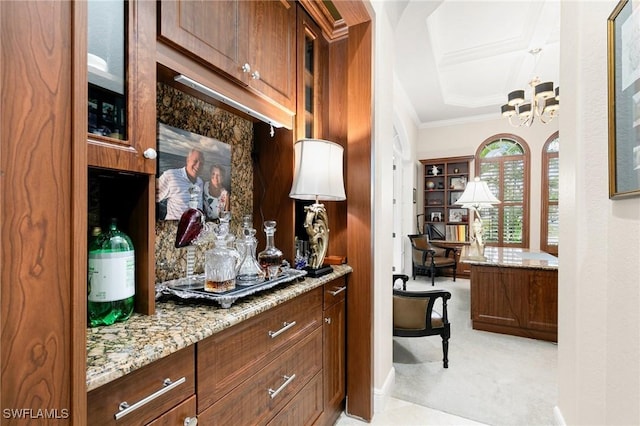 bar featuring a chandelier, light carpet, crown molding, and light stone countertops