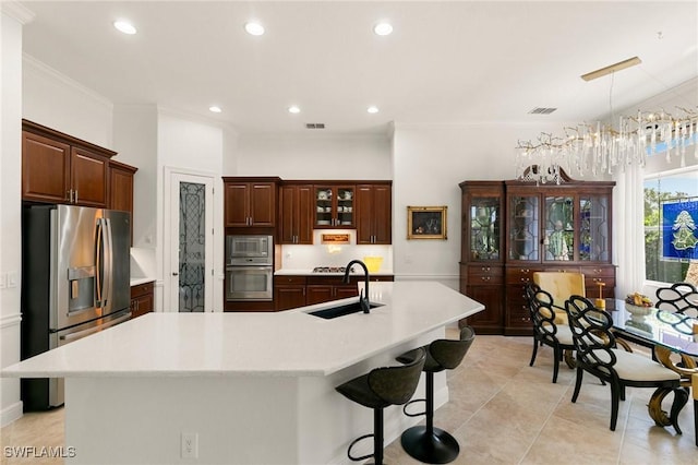 kitchen featuring a center island with sink, pendant lighting, sink, and stainless steel appliances