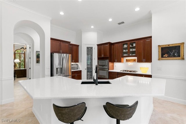 kitchen with a kitchen breakfast bar, a spacious island, sink, and stainless steel appliances