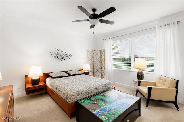 carpeted bedroom with ceiling fan and ornamental molding