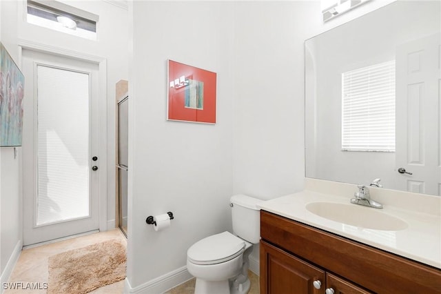 bathroom with an enclosed shower, vanity, toilet, and tile patterned floors