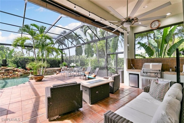 view of patio / terrace with glass enclosure, ceiling fan, a grill, an outdoor living space with a fire pit, and area for grilling