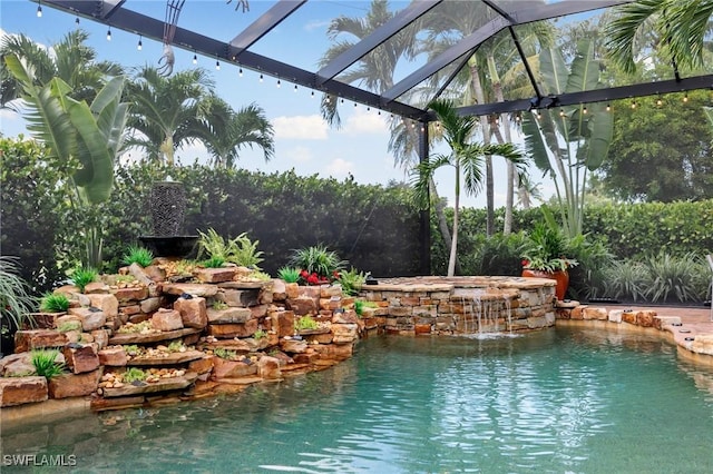 view of swimming pool featuring pool water feature and a lanai